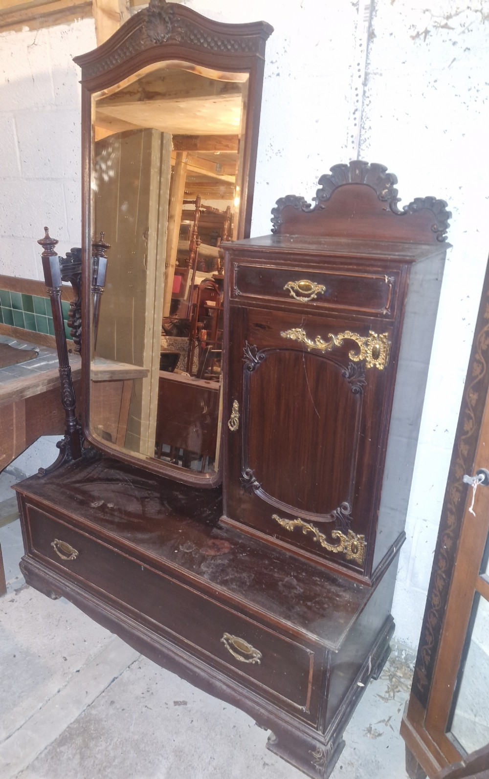 A late Victorian dark mahogany dressing table featuring a tall central mirror, carved top pediment, attached side cupboard with brass mounts, and a lower wide drawer. View III