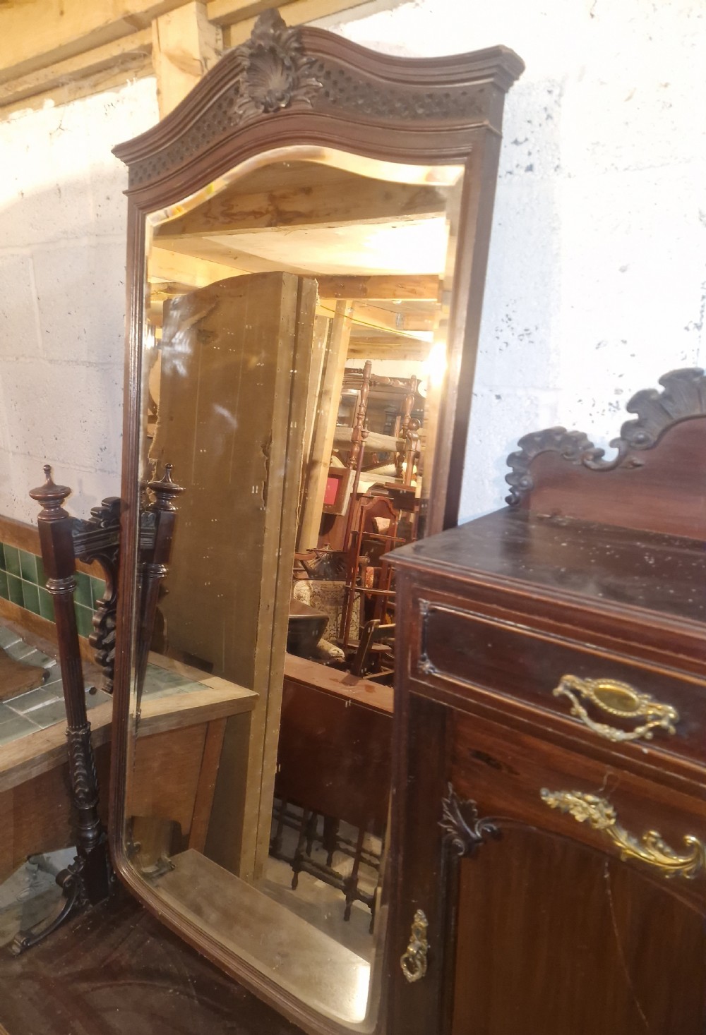 A late Victorian dark mahogany dressing table featuring a tall central mirror, carved top pediment, attached side cupboard with brass mounts, and a lower wide drawer. View V