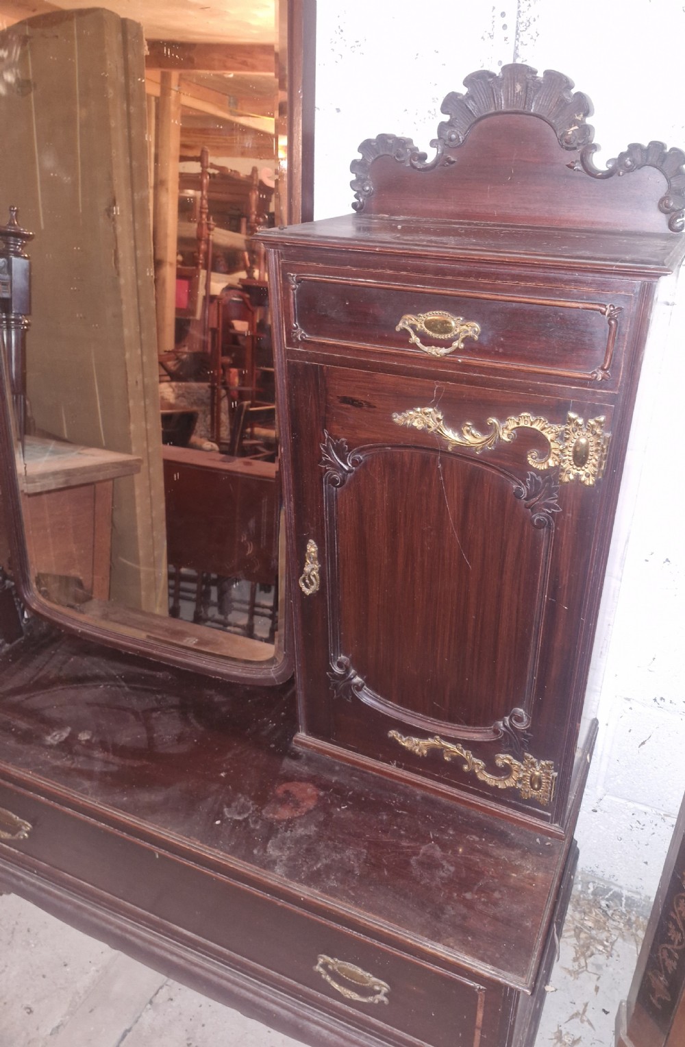 A late Victorian dark mahogany dressing table featuring a tall central mirror, carved top pediment, attached side cupboard with brass mounts, and a lower wide drawer. View VII