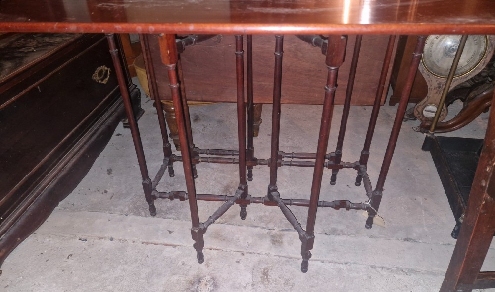 An Edwardian warm brown mahogany double spider gateleg occasional table with folded leaves and slender turned legs. View II