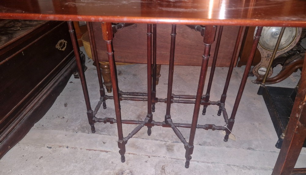 An Edwardian warm brown mahogany double spider gateleg occasional table with folded leaves and slender turned legs. View III