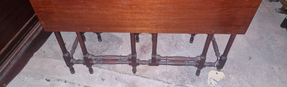 An Edwardian warm brown mahogany double spider gateleg occasional table with folded leaves and slender turned legs. View VI
