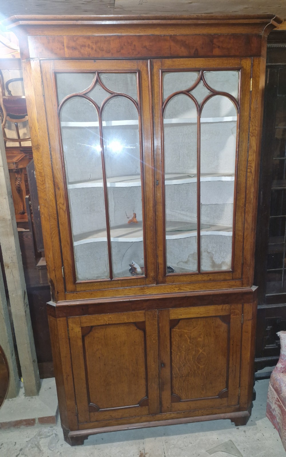 An early Victorian floor-standing Welsh corner cupboard crafted in oak and mahogany, featuring astragal glazed upper doors and solid panelled lower doors. View III