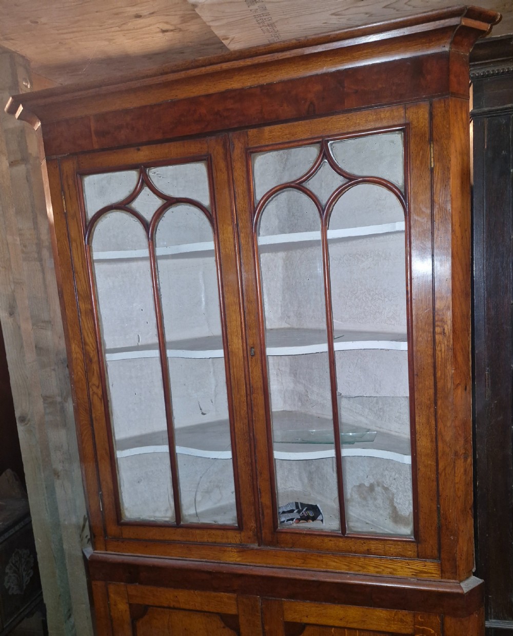 An early Victorian floor-standing Welsh corner cupboard crafted in oak and mahogany, featuring astragal glazed upper doors and solid panelled lower doors. View V