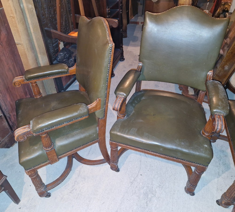 A pair of late Victorian oak desk armchairs upholstered in olive green leather with brass stud detailing and fluted front legs on castors. View III