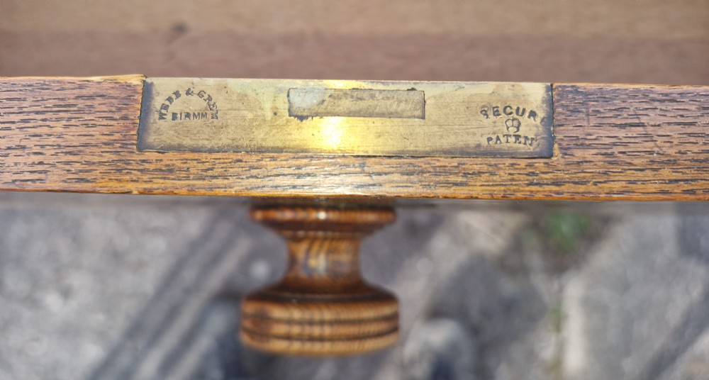 A late Victorian warm brown wood pedestal dressing table featuring ebonised stencilled accents, turned mirror supports, and nine drawers flanking a central kneehole. View XII