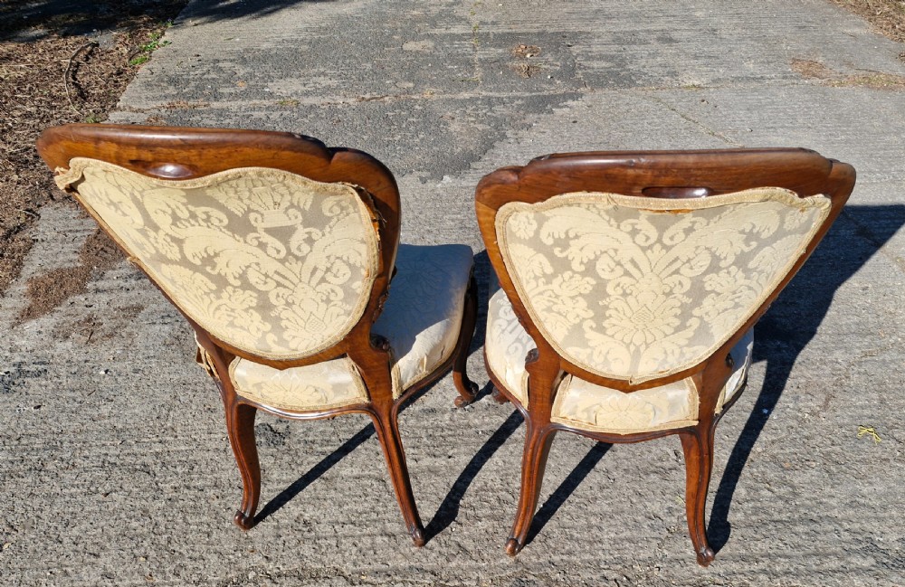 A pair of 19th-century Rococo Revival side chairs with carved dark wood frames, cabriole legs, and cream damask upholstered seats and backrests. View II