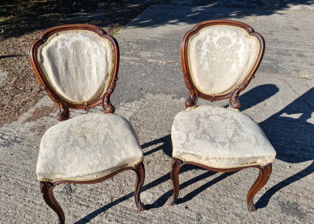 A pair of 19th-century Rococo Revival side chairs with carved dark wood frames, cabriole legs, and cream damask upholstered seats and backrests. View III