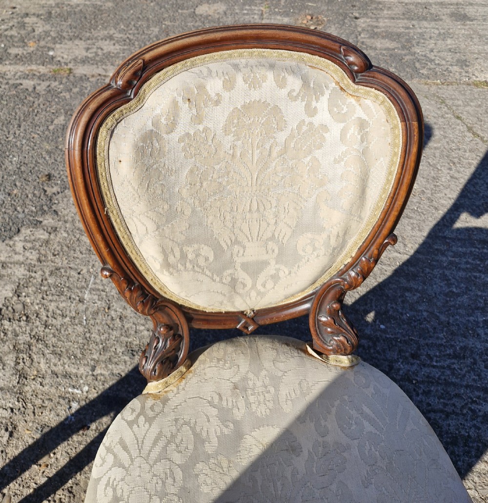 A pair of 19th-century Rococo Revival side chairs with carved dark wood frames, cabriole legs, and cream damask upholstered seats and backrests. View IX