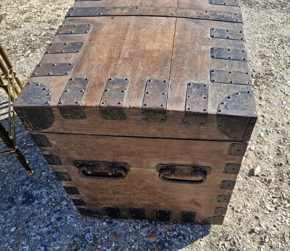 A rectangular Victorian oak chest with dark metal corner brackets, iron straps, stud detailing, and side handles. View X