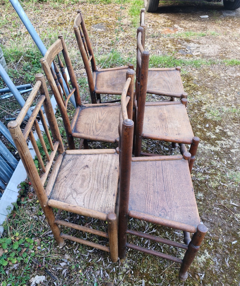 A set of six early nineteenth-century country wooden dining chairs featuring spindle backrests, solid timber seats, and turned legs with stretchers. View III