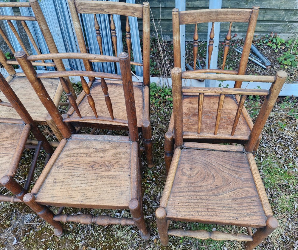 A set of six early nineteenth-century country wooden dining chairs featuring spindle backrests, solid timber seats, and turned legs with stretchers. View IV