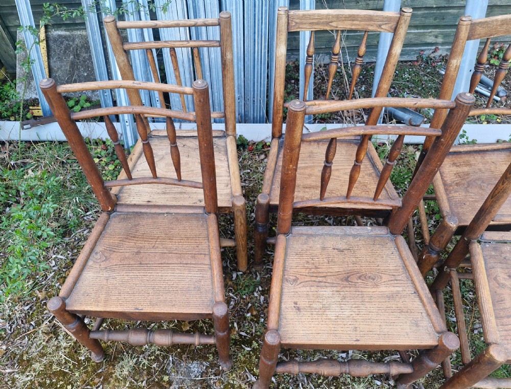 A set of six early nineteenth-century country wooden dining chairs featuring spindle backrests, solid timber seats, and turned legs with stretchers. View V
