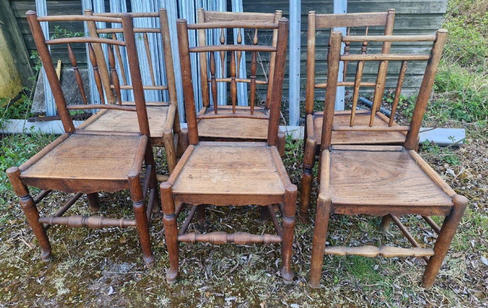 A set of six early nineteenth-century country wooden dining chairs featuring spindle backrests, solid timber seats, and turned legs with stretchers. View VI