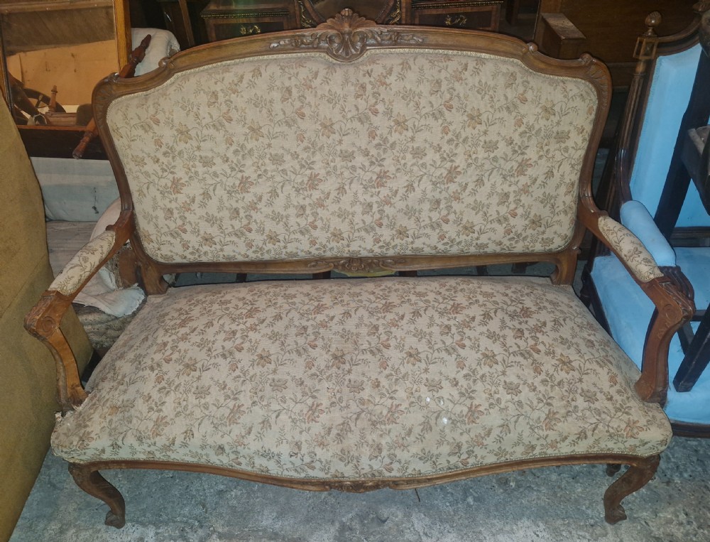 A small French Louis XV style two-seater sofa with a carved walnut frame, cabriole legs, floral top cresting, and patterned beige textile upholstery. View II