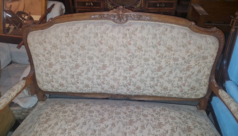 A small French Louis XV style two-seater sofa with a carved walnut frame, cabriole legs, floral top cresting, and patterned beige textile upholstery. View XIII