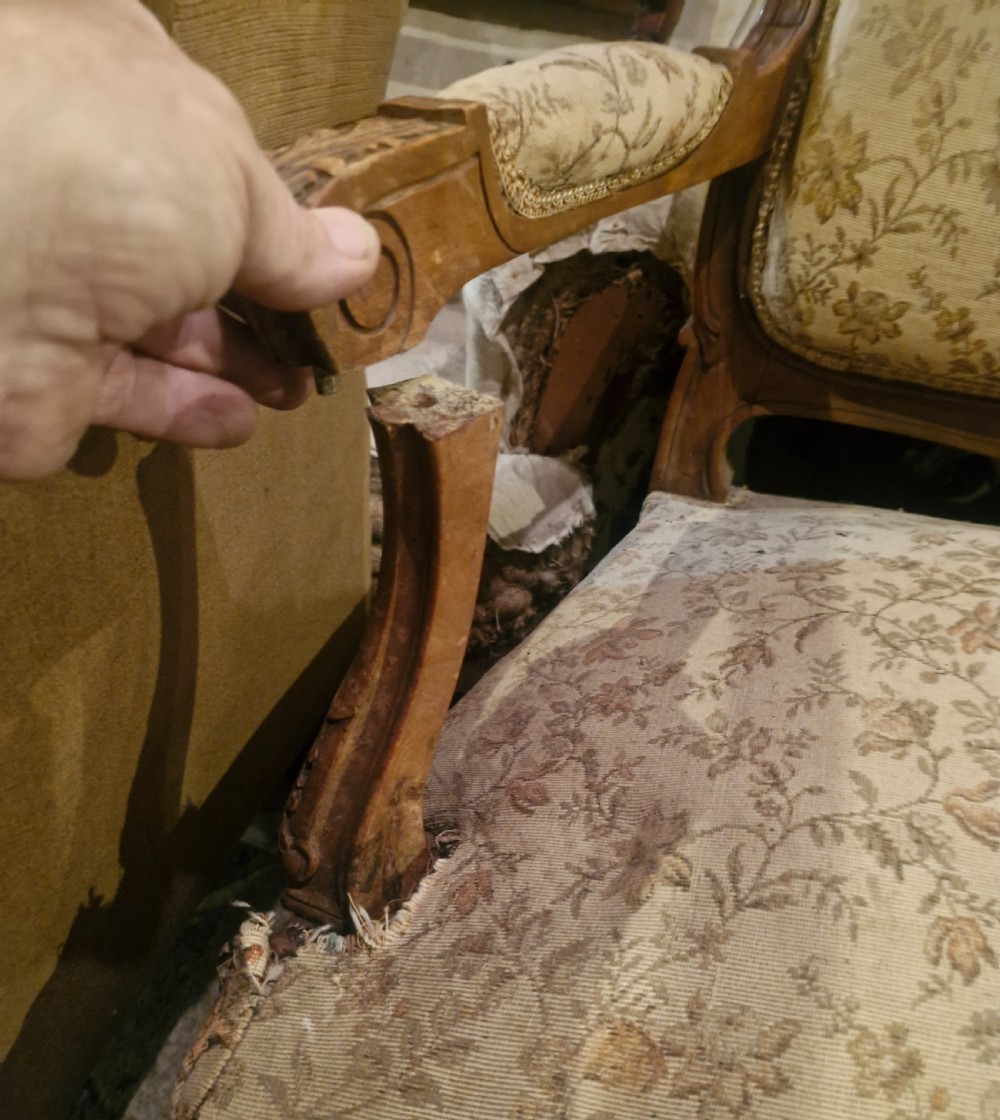 A small French Louis XV style two-seater sofa with a carved walnut frame, cabriole legs, floral top cresting, and patterned beige textile upholstery. View XVIII
