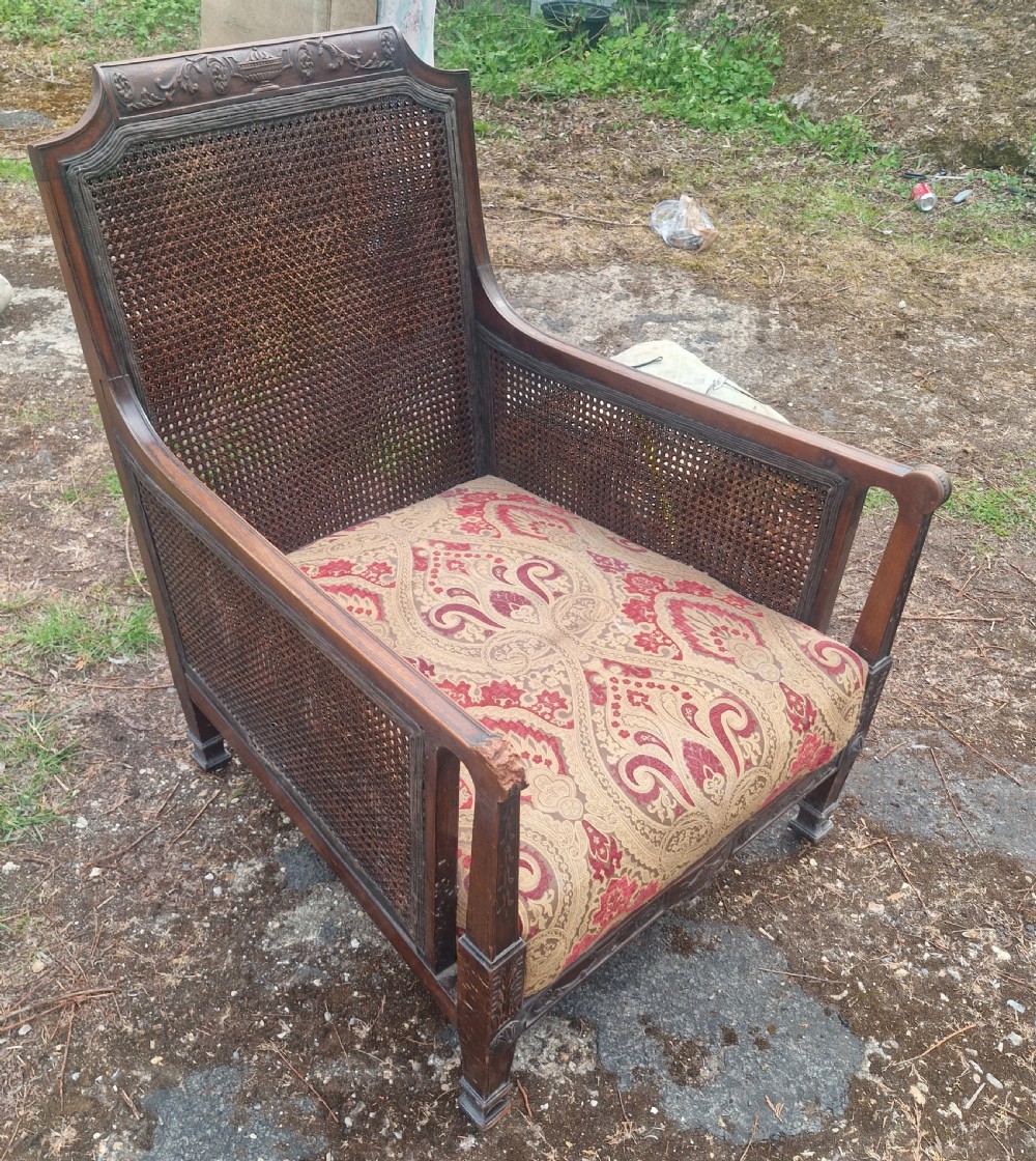 An Edwardian mahogany bergere armchair with woven cane panels on the back and sides and a patterned upholstery seat cushion. View VII