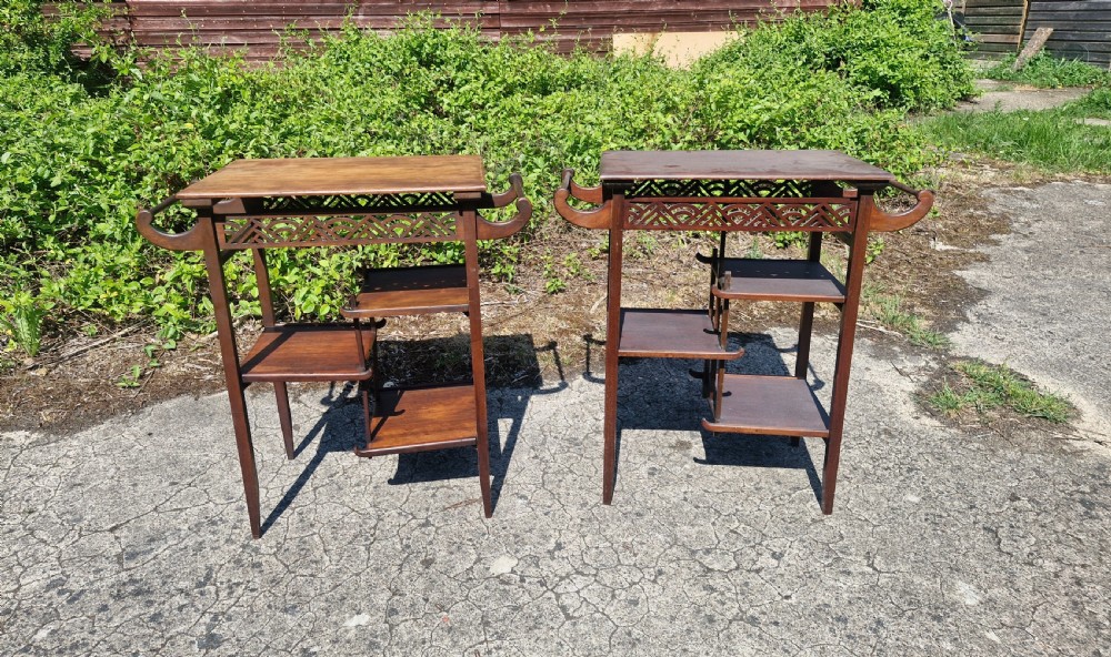 A pair of mahogany Anglo-Japanese occasional tables featuring pierced fretwork friezes, side handles, and staggered lower shelves. View III