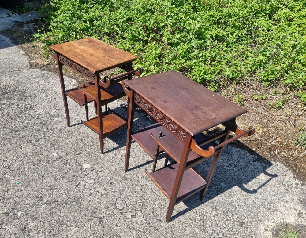 A pair of mahogany Anglo-Japanese occasional tables featuring pierced fretwork friezes, side handles, and staggered lower shelves. View VI