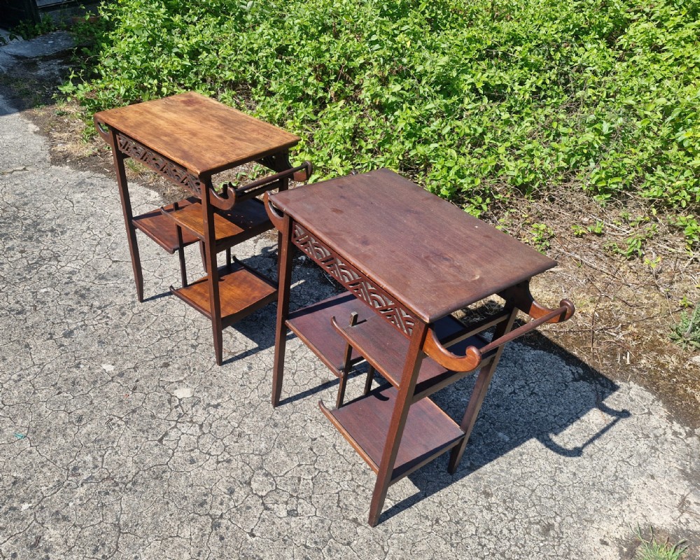 A pair of mahogany Anglo-Japanese occasional tables featuring pierced fretwork friezes, side handles, and staggered lower shelves. View VII