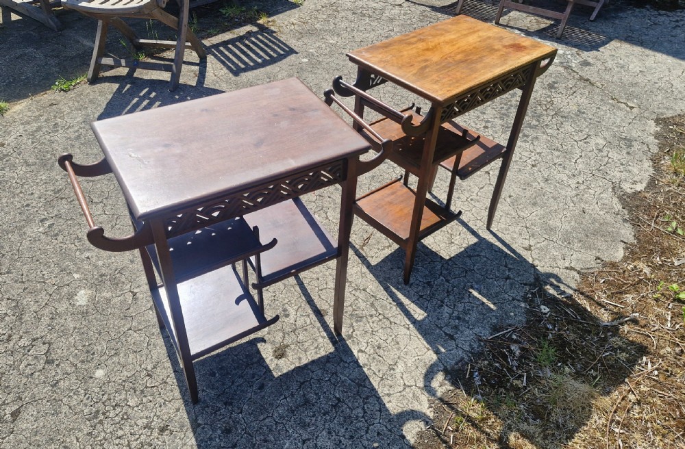 A pair of mahogany Anglo-Japanese occasional tables featuring pierced fretwork friezes, side handles, and staggered lower shelves. View VIII