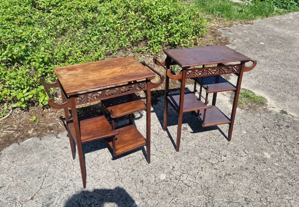A pair of mahogany Anglo-Japanese occasional tables featuring pierced fretwork friezes, side handles, and staggered lower shelves. View IX