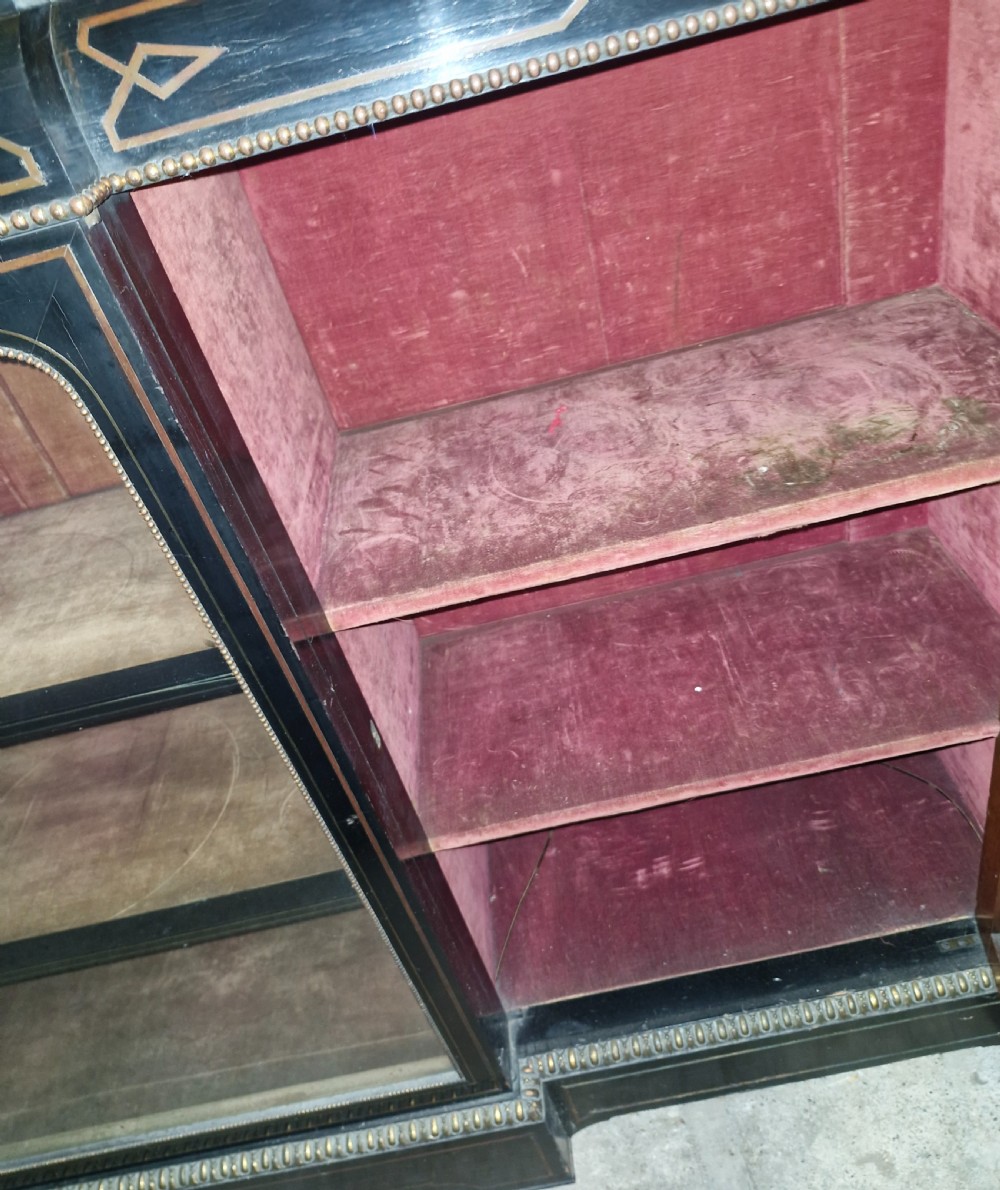 A Victorian ebonised three-door credenza featuring a central glazed compartment flanked by panelled doors decorated with oval hand-painted porcelain plaques and gilt metal mounts. View V