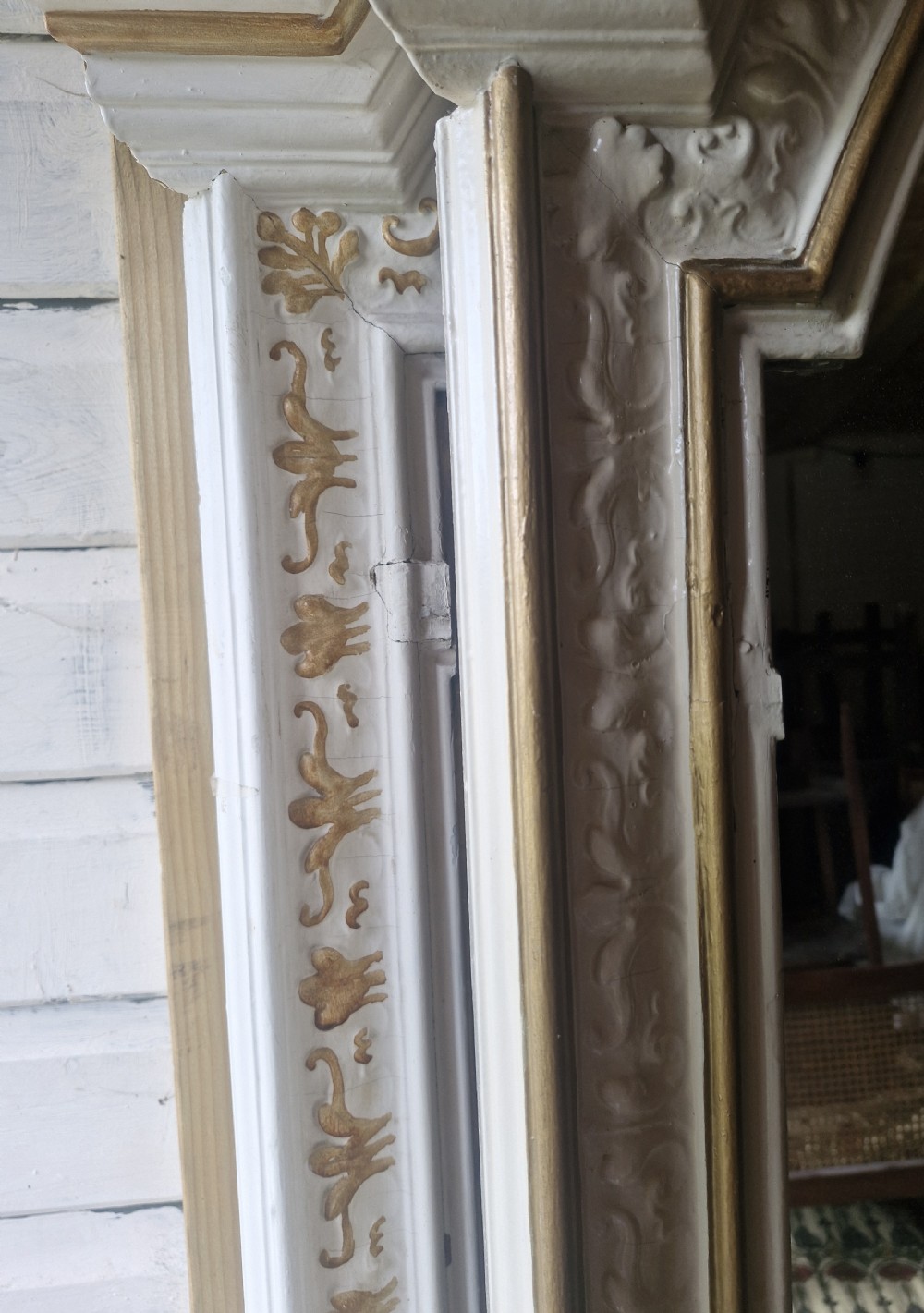 A 19th-century arched mirror featuring an off-white painted frame with exposed gilt moulding and a carved central crest. View XIV