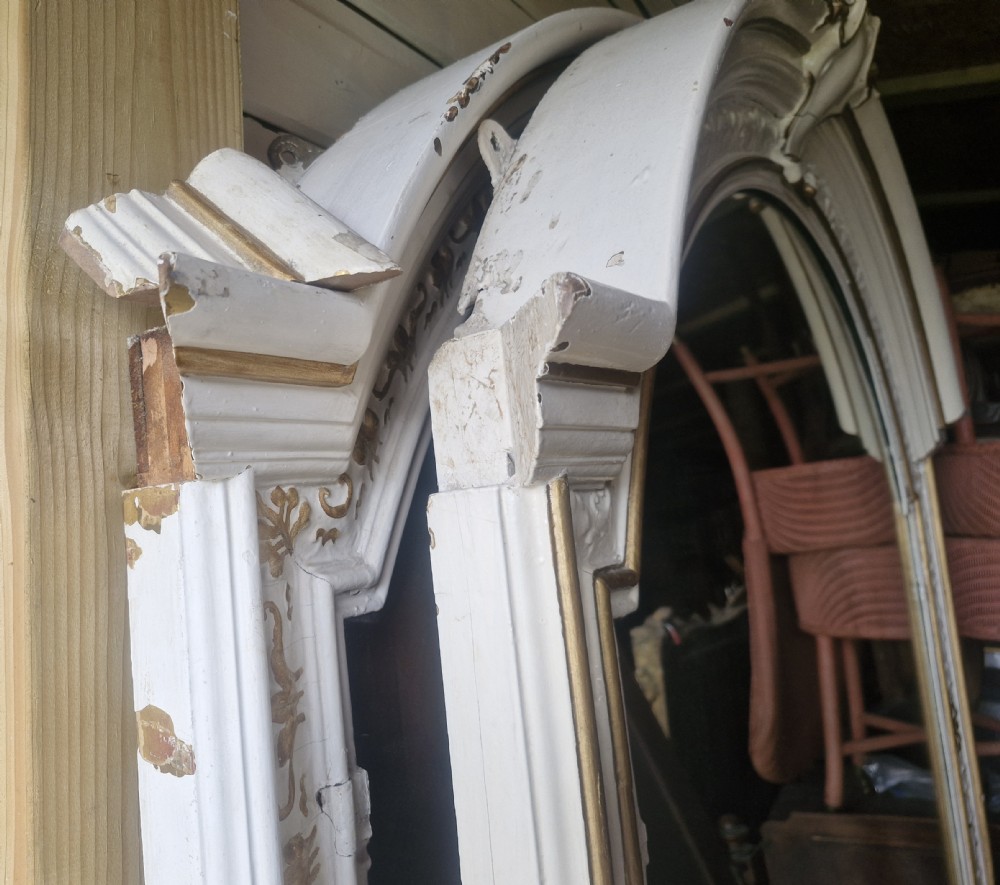 A tall, arched 19th-century hall mirror featuring a cream painted finish over original gilded moulding with a top central crest. View XII