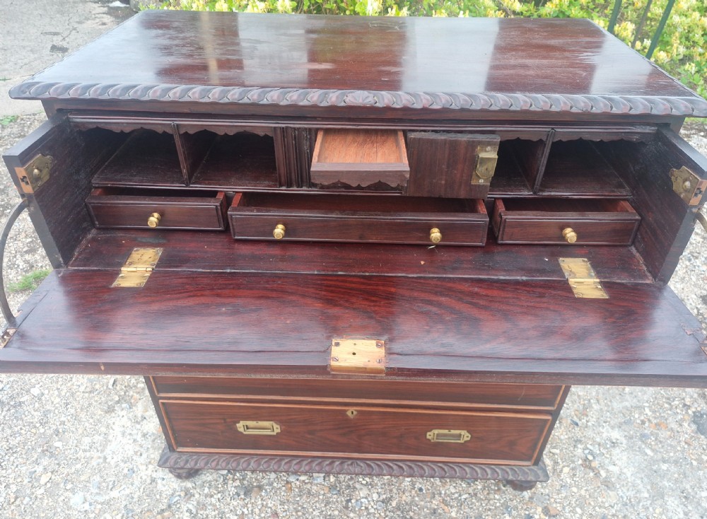 A four-drawer dark rosewood Anglo-Indian campaign secretaire chest featuring recessed brass handles, diamond escutcheons, and carved gadrooned borders. View III
