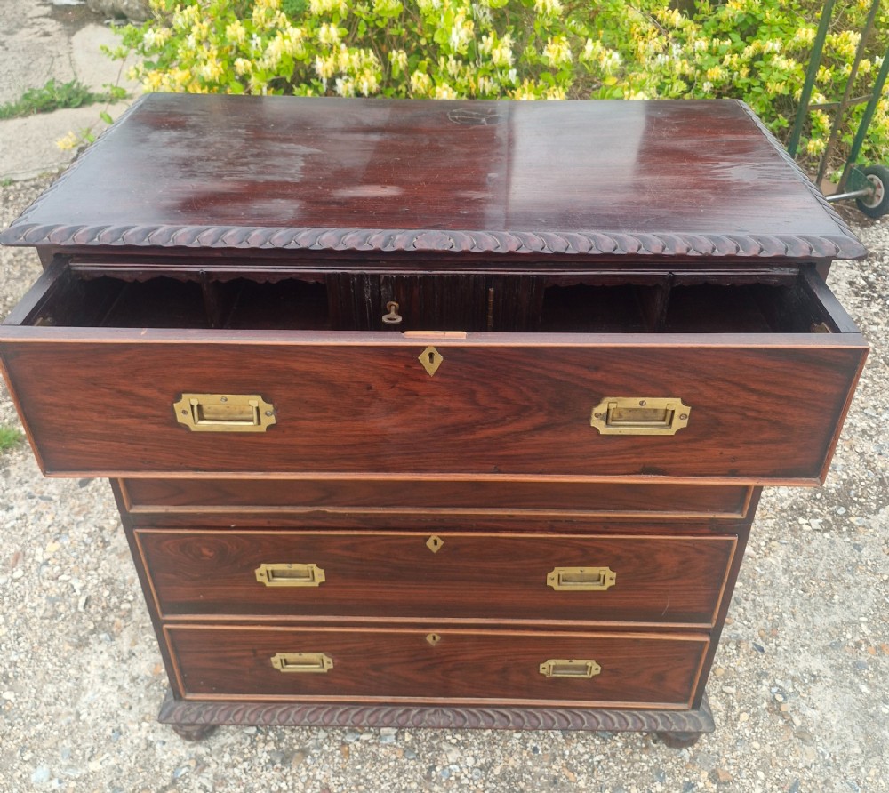 A four-drawer dark rosewood Anglo-Indian campaign secretaire chest featuring recessed brass handles, diamond escutcheons, and carved gadrooned borders. View VII