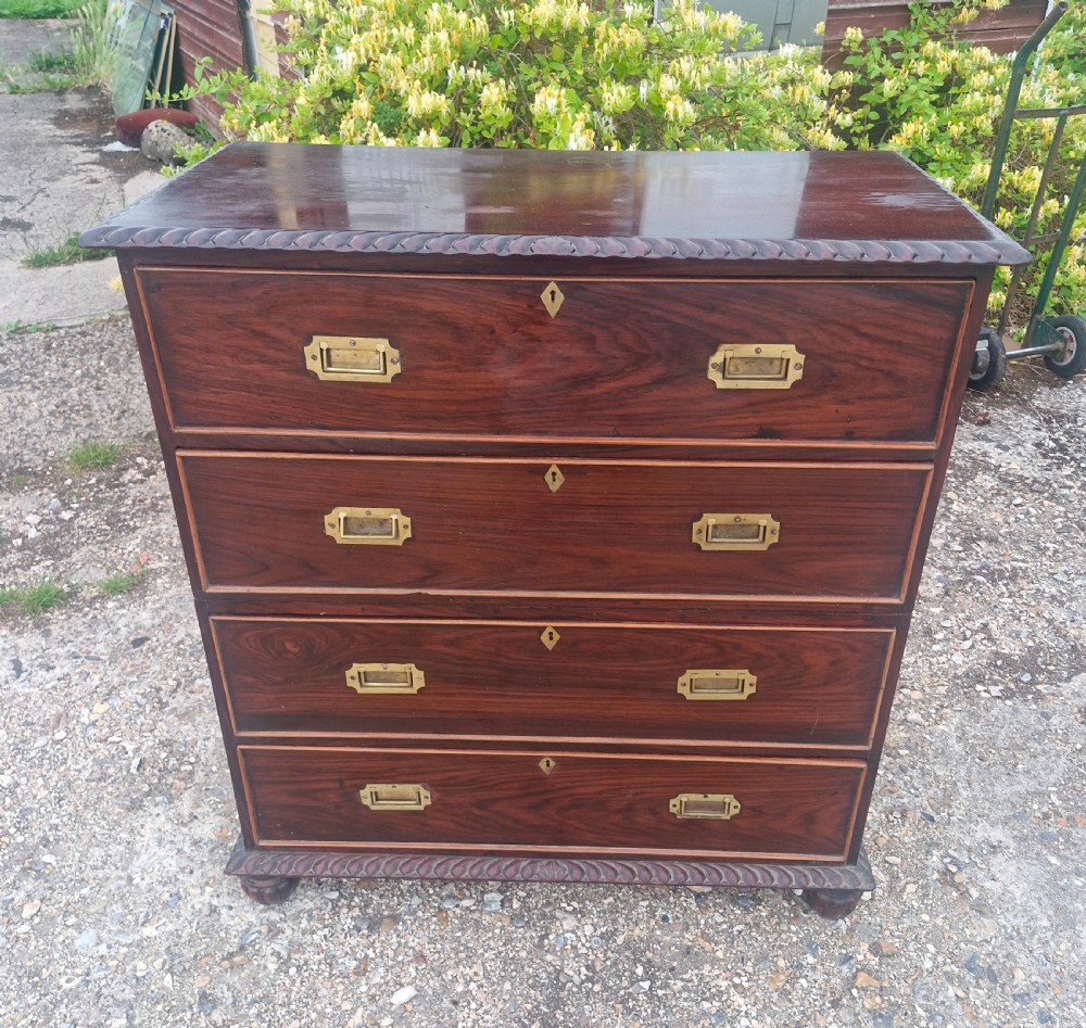 A four-drawer dark rosewood Anglo-Indian campaign secretaire chest featuring recessed brass handles, diamond escutcheons, and carved gadrooned borders. View IX