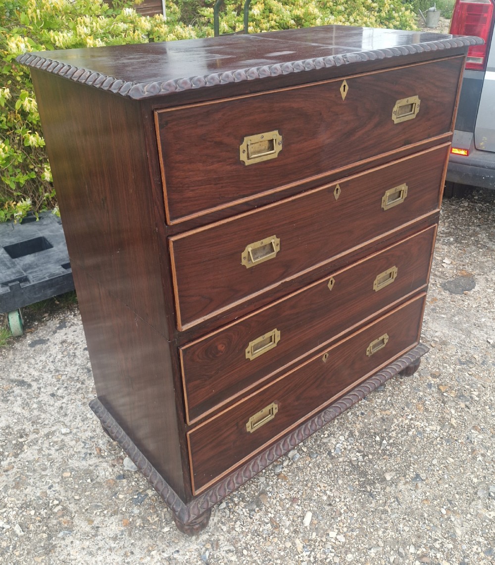 A four-drawer dark rosewood Anglo-Indian campaign secretaire chest featuring recessed brass handles, diamond escutcheons, and carved gadrooned borders. View XII