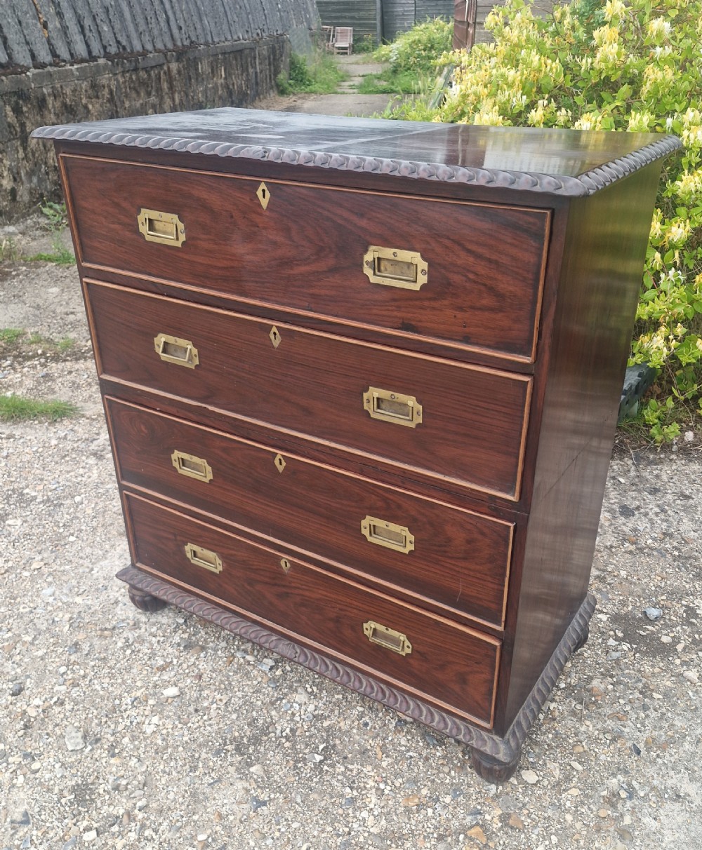A four-drawer dark rosewood Anglo-Indian campaign secretaire chest featuring recessed brass handles, diamond escutcheons, and carved gadrooned borders. View XIII