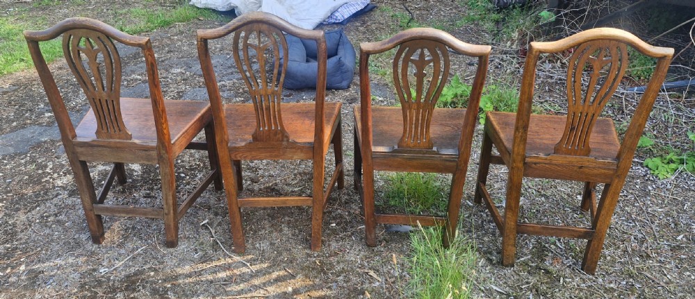 Set of four early nineteenth-century country dining chairs crafted from dark wood with pierced balloon splat backs and solid seats. View III