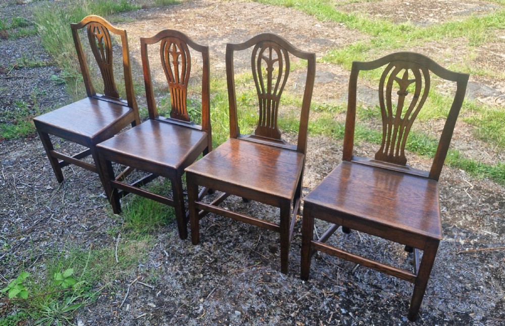 Set of four early nineteenth-century country dining chairs crafted from dark wood with pierced balloon splat backs and solid seats. View IV