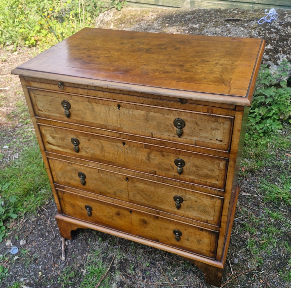Early 20th century walnut chest of drawers with brushing slide. 