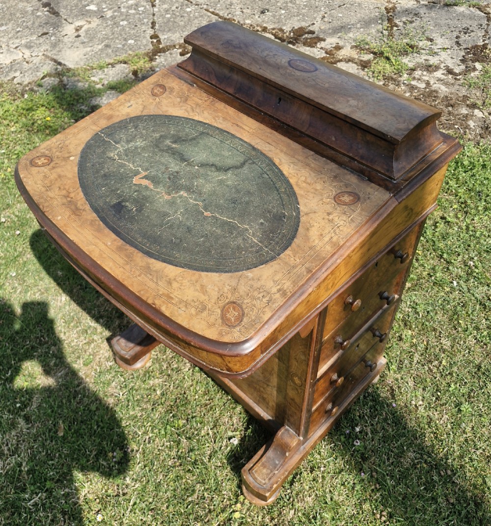 A Victorian walnut Davenport desk featuring a green leather writing slope, floral marquetry inlay, a raised top stationery box, and four side drawers.