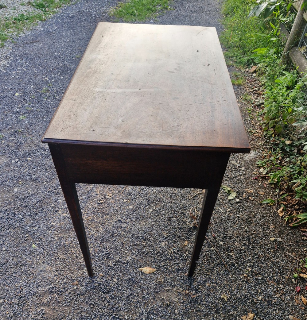 A late Georgian mahogany side table featuring a single long drawer with two brass swan-neck handles and four square tapered legs. View III