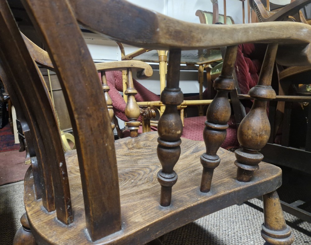 A dark-stained Victorian Windsor armchair with a spindled high back, carved central splat, shaped armrests, solid seat, and turned wooden legs. View XIV
