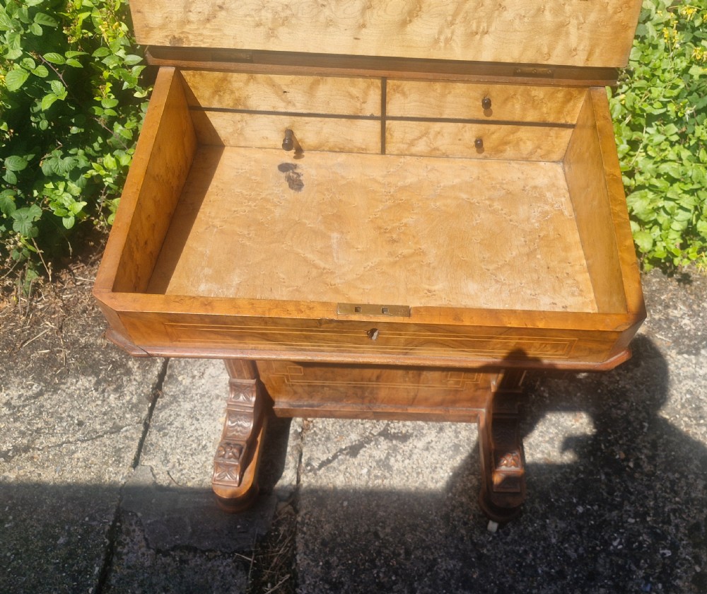 A Victorian burr walnut Davenport desk with a sloped red leather writing surface, inlaid top cresting, and side drawers. View VI