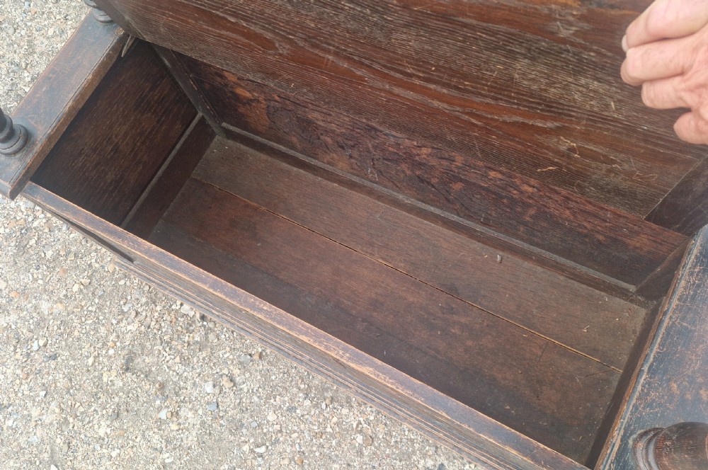 Late Victorian dark oak monks hall seat featuring intricate carved foliate panels, turned arm supports, and an integrated storage chest base. View X