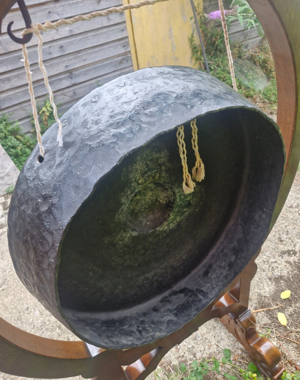 A late Victorian floor-standing dinner gong framed in carved dark oak with a suspended bronze disc. View III