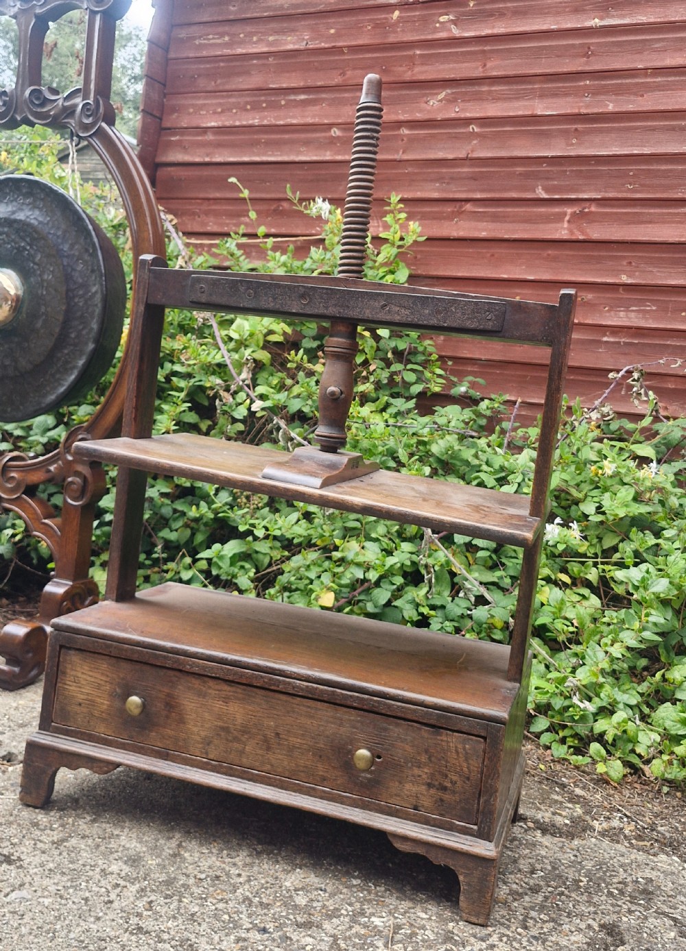 An antique Georgian dark oak tabletop book press featuring a central wooden threaded screw stem, an upper frame, and a base drawer with brass knobs. View V