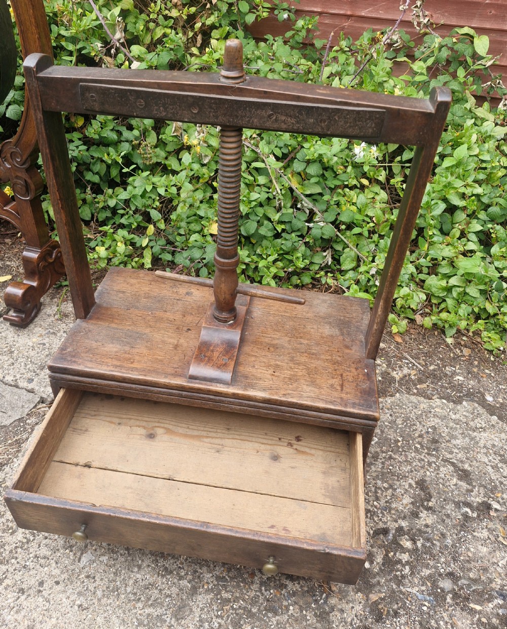 An antique Georgian dark oak tabletop book press featuring a central wooden threaded screw stem, an upper frame, and a base drawer with brass knobs. View VIII