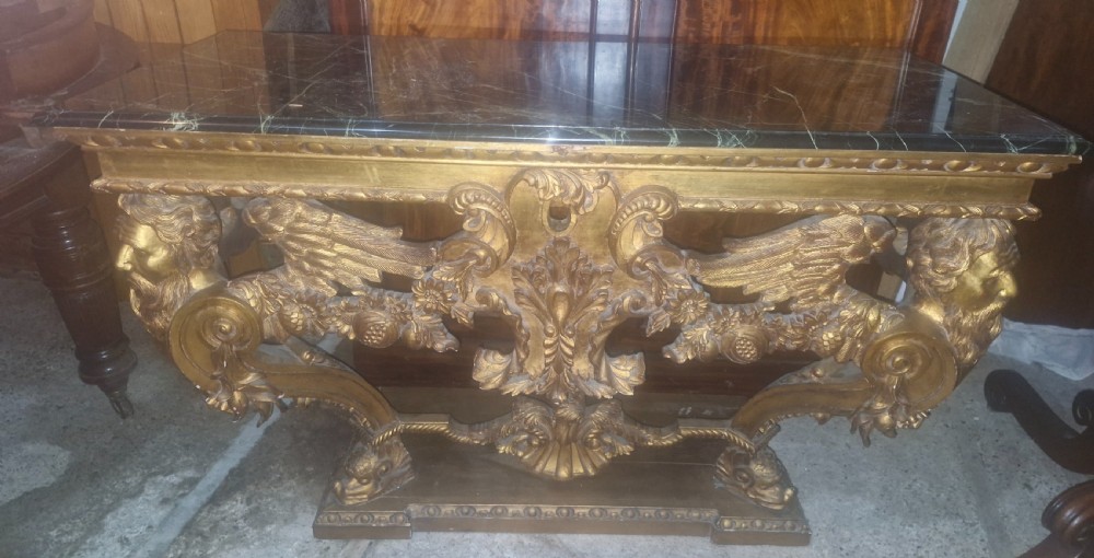 Ornate carved marble top gilt console table.