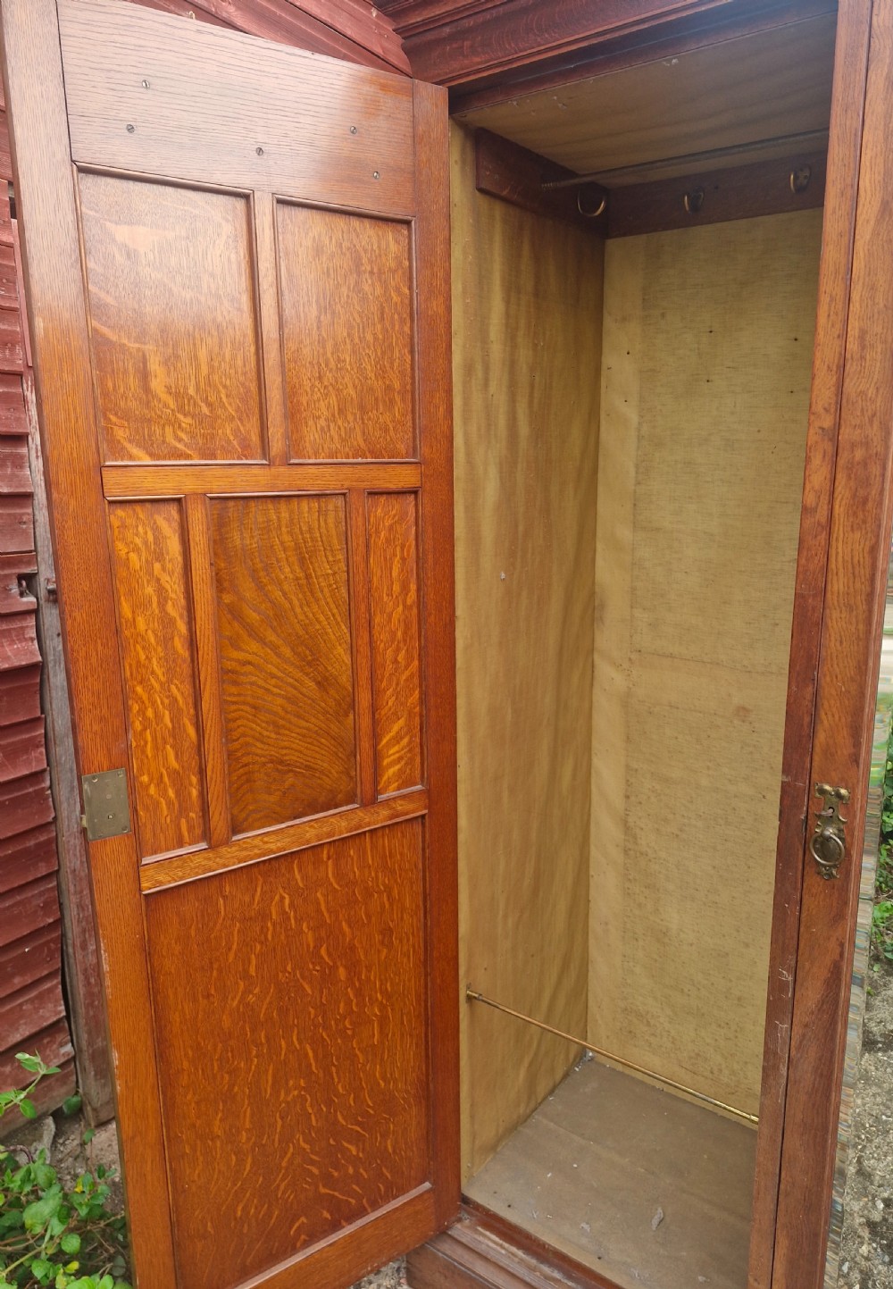 A large Edwardian oak triple wardrobe featuring carved side panels, an arched central mirror door, and traditional brass handles. View VIII