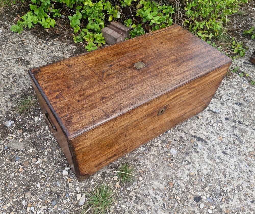 An early 20th century rectangular teak trunk featuring a hinged lid, a central metal lockplate, and side carrying handles. View IV