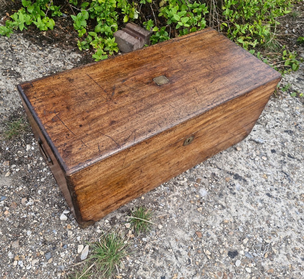 An early 20th century rectangular teak trunk featuring a hinged lid, a central metal lockplate, and side carrying handles. View VI